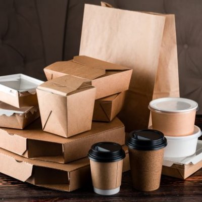 a pile of brown and white cardboard food boxes and bags